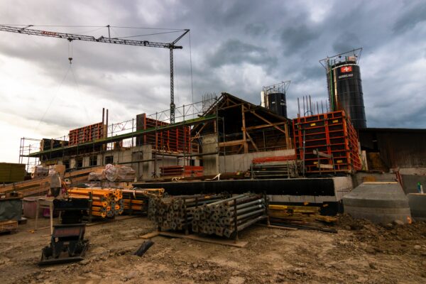 An empty construction site of rebar with a crane in the background. Climate AI could support resilience and more effective planning. 